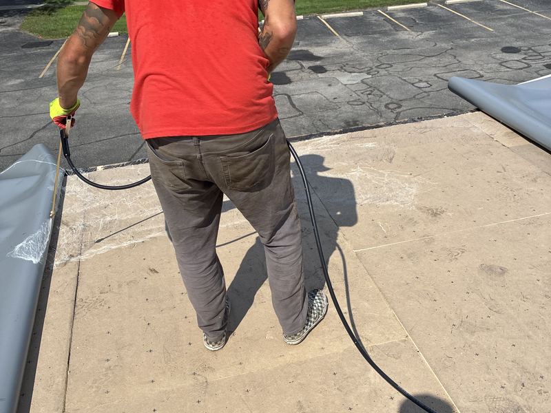 Crew installing a flat roof membrane