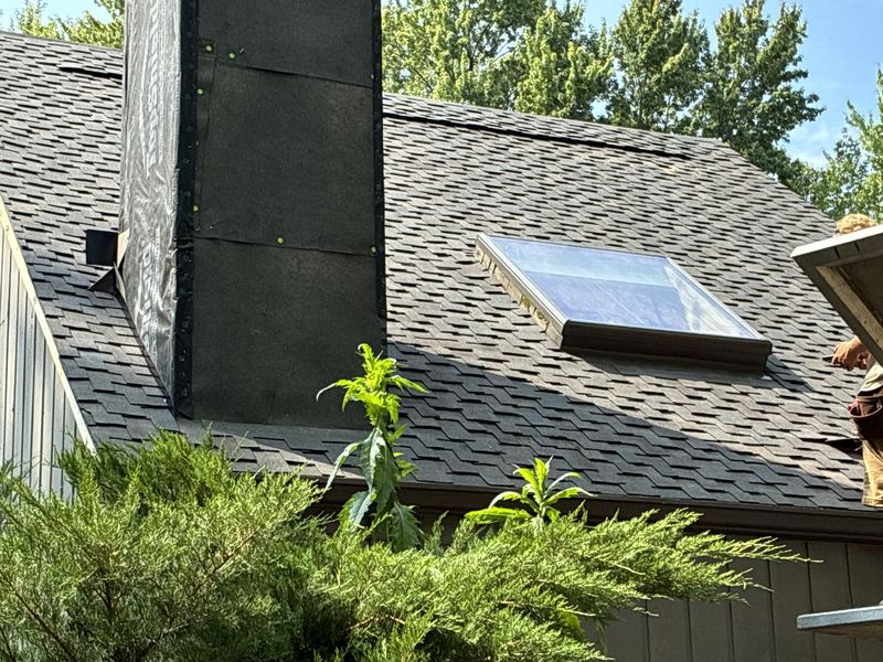 Skylight replacement with new flashing beside a chimney